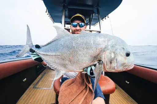 Guest holding giant trevally catch Maldives